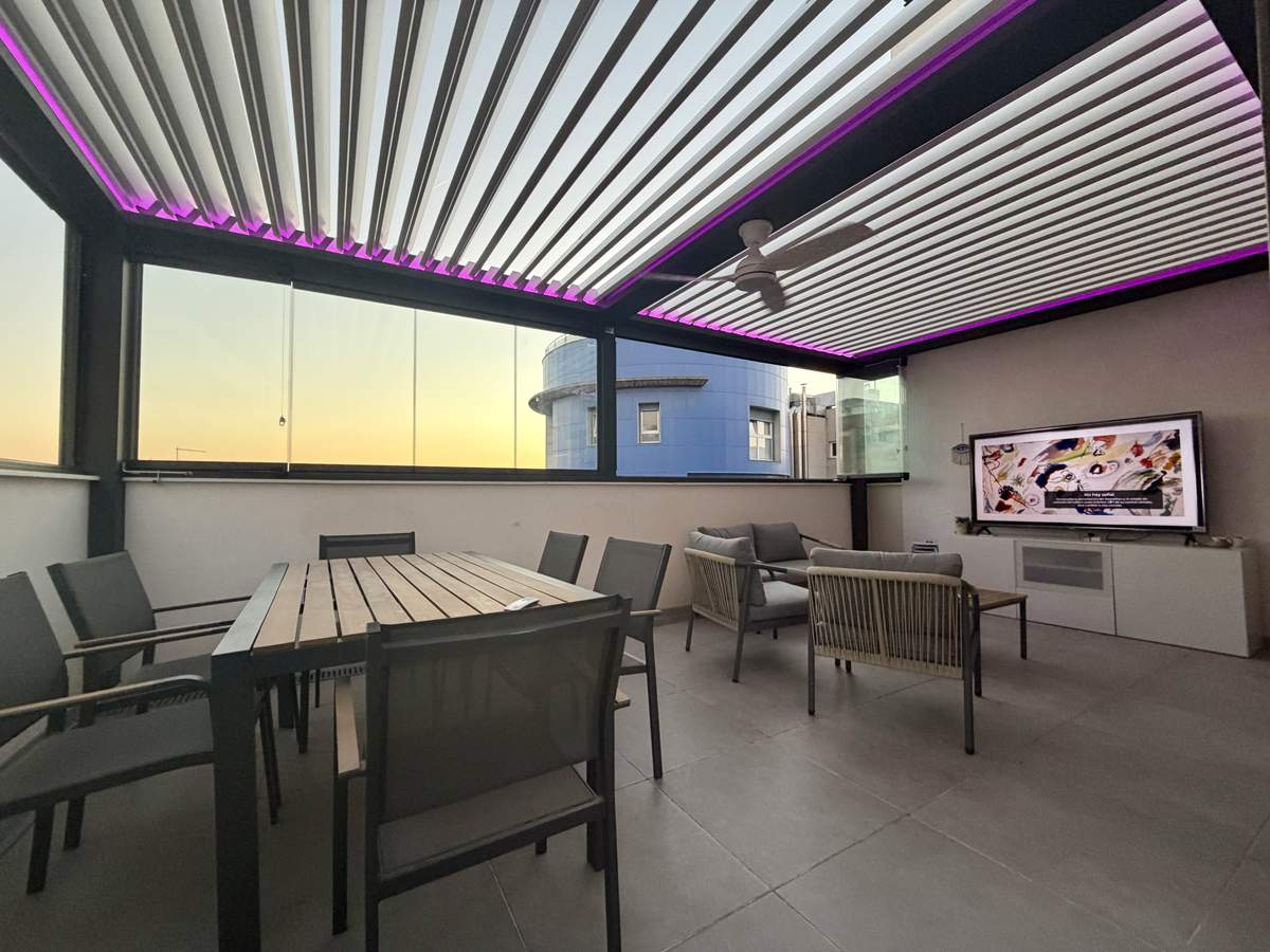 Iluminación LED en las lamas de la pérgola bioclimática al atardecer