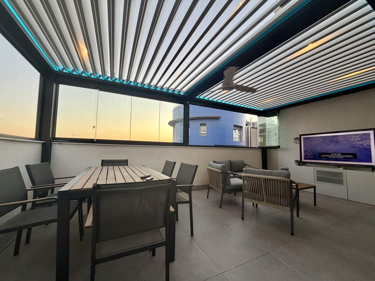Pérgola bioclimática de lamas orientables con iluminación LED perimetral en un ático