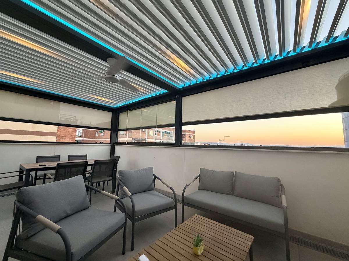 Salón exterior cubierto por pérgola bioclimática de lamas orientables